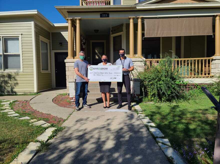 Iowa City Catholic Workers stand in front of the Victorian-style home they bought as their second "house of hospitality" for immigrants and refugees to stay in.