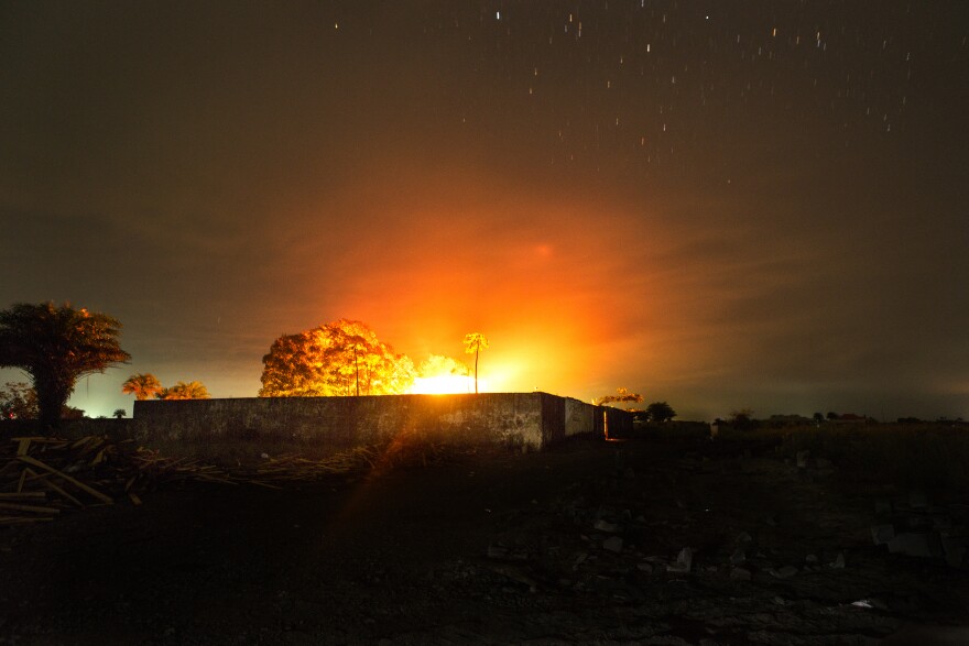 The glow from a crematorium fire lights up the night sky where bodies of people who died from Ebola are cremated in Monrovia, Liberia.