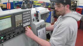 Joe Pelton operates a computer-controlled machine that drills a tiny hole into a needle that is used to make microchips. He works at AccuRounds, an advanced manufacturing facility in Avon, Mass.