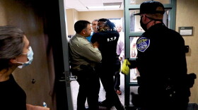 A Rochester Police Department officer draws his Taser on Free the People Roc organizer Stanley Martin, though he did not fire it.