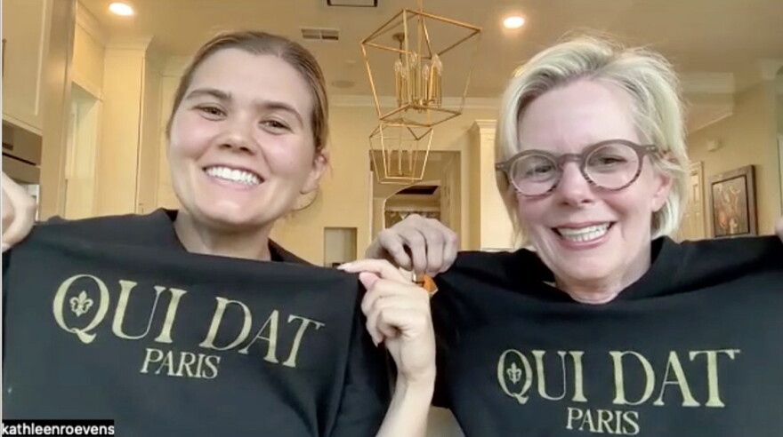 Abby and Kathleen Roevens (left to right) pose with a shirt that says 'Oui Dat" on October 2, 2026. The Roevens are New Orleans Saints fans who traveled to support the team in the NFL's first regular-season game in Paris, France.