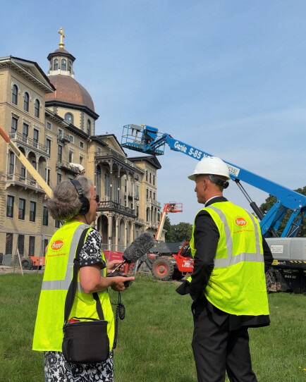 Father Luke Strand talks with WUWM's Susan Bence outside Henni Hall.