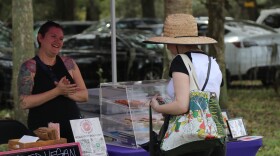 Brie-Anne Ezratty, 31, owner of Baked Vegan, greets customer Makayla Rutski, 23, at the farmers market at Critter Creek Sanctuary, Gainesville, Florida, Sunday, Feb. 11, 2024. (Nicole Beltran/WUFT News)