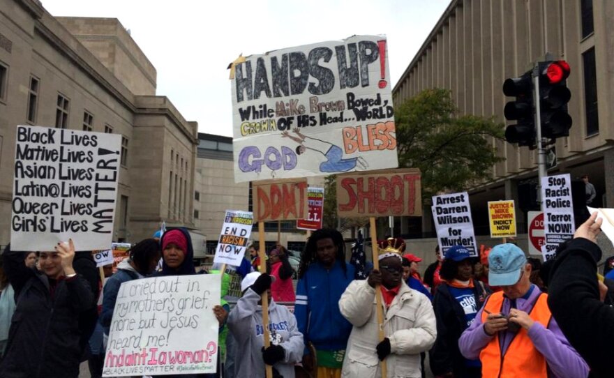 Signs protest police killings at the Oct. 11 march downtown.