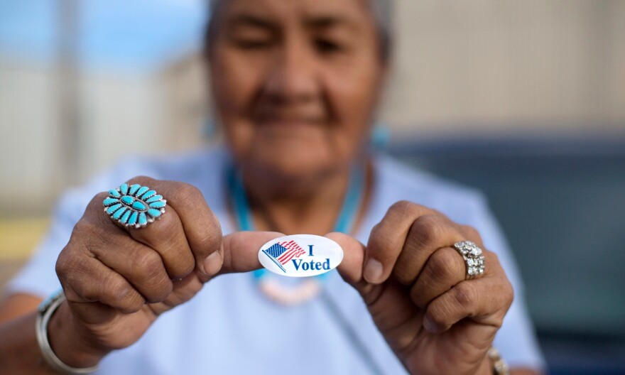 A woman shows off her ‘I voted’ sticker in Window Rock, Arizona, in August 2018.