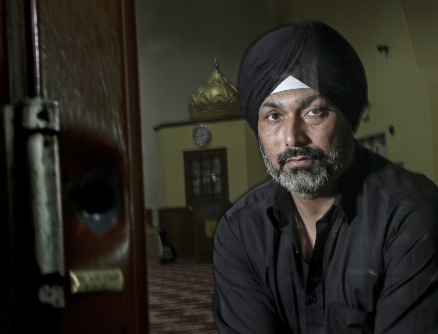 Pardeep Singh Kaleka poses for a portrait in the Sikh Temple in Oak Creek, Wis., on June 1, 2019. At left is a bullet hole in a door frame of the temple, left as a reminder of the 2012 shooting.