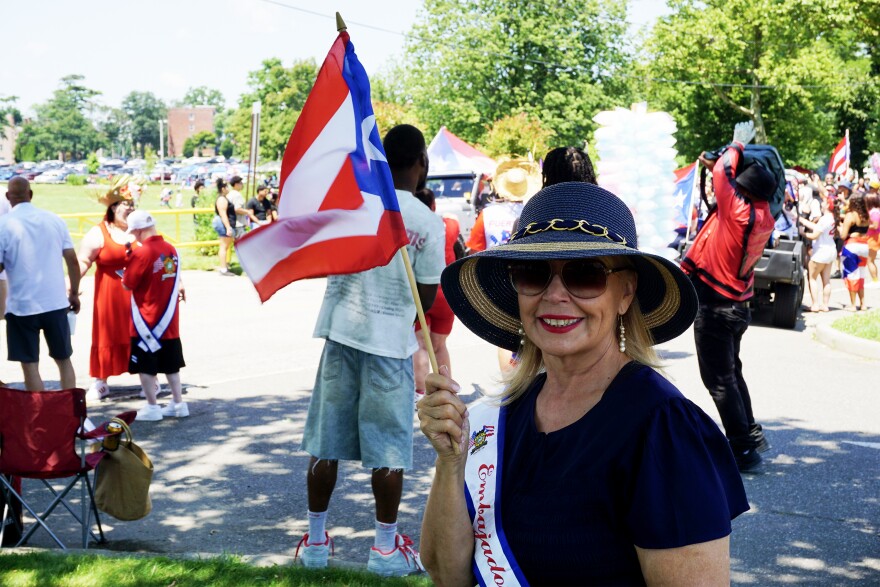 Carmen Colon, one of three ambassadors for the 2026 Puerto Rican Parade of Fairfield County, smiles as she waves the flag that was once outlawed from 1948 to 1957.
