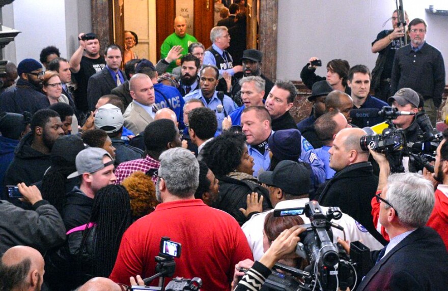 At a raucous public hearing on Jan. 28, 2015, dozens of officers stood in unison to oppose the civilian oversight measure, calling it “anti-police” legislation. At one point, a scuffle broke out after the union business manager allegedly pushed a Black woman, breaking her glasses. Activist Kayla Reed, at right of the man in the red shirt, was urging people to get back to their seats so the meeting wouldn’t be cut short, she said.