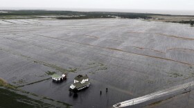A pickup truck drives on a flooded road past a farm house that is surrounded by flooded fields from tropical storm Florence in Hyde County, NC., Saturday, Sept. 15, 2018. (Steve Helber/AP)