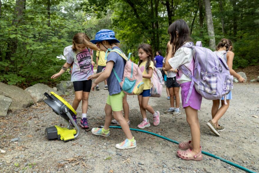 Back at the main camp, Hale Day campers cool off by a misting fan.  (Robin Lubbock/WBUR)