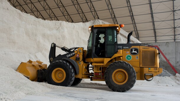 An ODOT loader digs into a pile of salt to fill dump trucks.