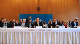 United Nations Secretary-General Ban Ki-moon, flanked by Russian Foreign Minister Sergey Lavrov and U.S. Secretary of State John Kerry, gavels open the Geneva II conference in Montreux, Switzerland, on January 22, 2014.