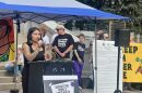 People stand behind a podium in front of the steps to the Colorado State Capitol building