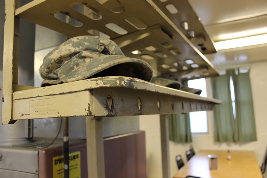 Soldiers place their hats on rack just inside the mess hall doors before eating breakfast in the controlled monitoring area at JBLM.