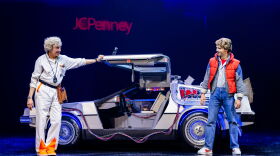 Marty and Doc stand next to the Delorean
