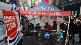 People wait in line to get tested for COVID-19 at a testing facility in Times Square in New York City.