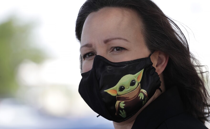 U.S. Senate candidate MJ Hegar wears a Baby Yoda mask while early voting on July 9th.