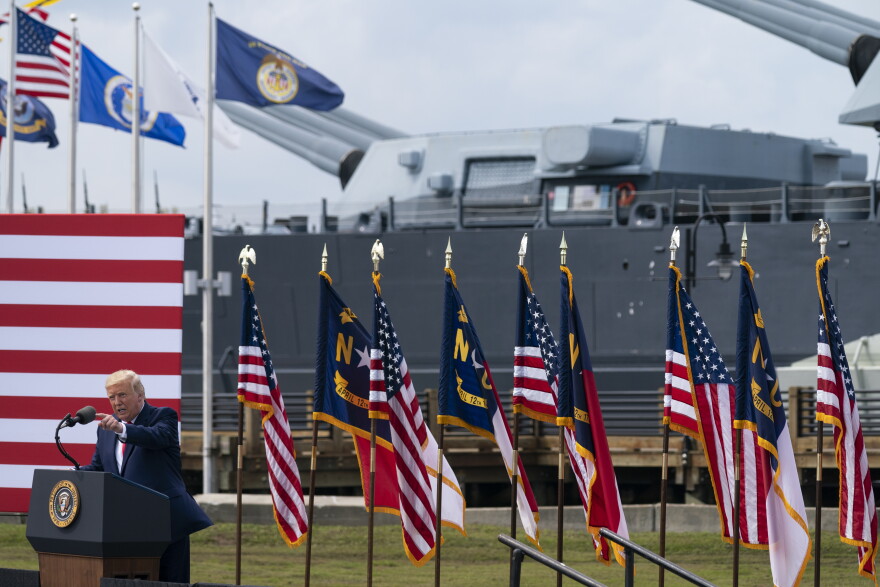 With the USS Battleship North Carolina in the background, President Donald Trump speaks during an event to designate Wilmington as the first American World War II Heritage City, Wednesday, Sept. 2, 2020, in Wilmington, N.C. 