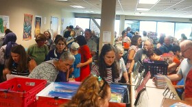 Patrons crowd the children's section in the first minutes of the CALS used book sale.