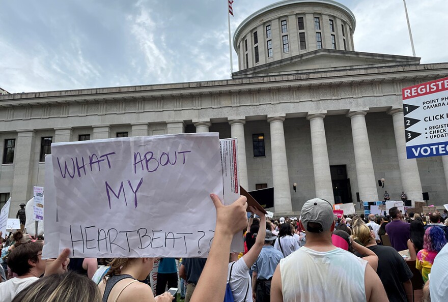 A protestor holds a sign referencing the six-week abortion ban, which supporters call the "heartbeat" law, at a demonstration at the Ohio Statehouse on Sunday, June 26, 2022.
