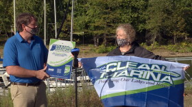 Indiana Department of Environment Management assistant commissioner Julia Wickard, right, presents a plaque and a flag to Lake Monroe Sailing Association commodore Jeff Watson Thursday.
