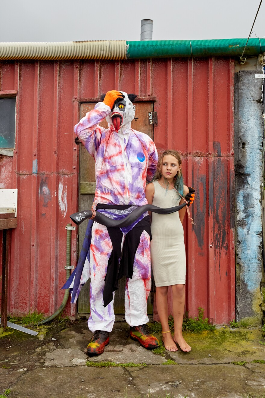 An Okalolie poses with Savanna Green. After quickly taking off his mask to identify himself, the two posed for a picture, like they've done every year since Savanna was a little girl.