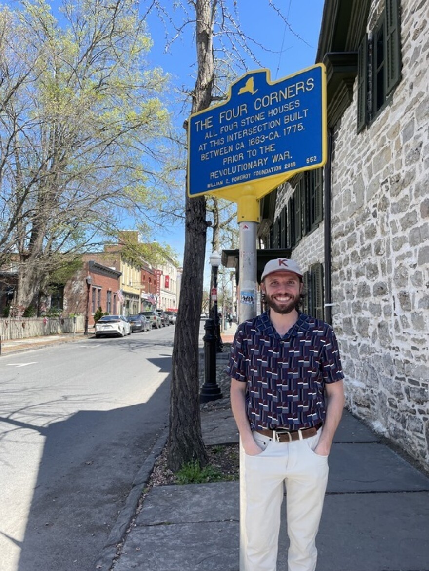 Kingston historian Taylor Bruck stands under the state placard honoring the intersection — a surprisingly popular local attraction.