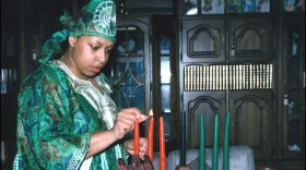 Tech. Sgt. Jennifer Myers (above), 66th Air Base Wing noncommissioned officer in charge of the Military Equal Opportunity office, demonstrates a Kwanzaa ritual where she lights a candle in the Kinara.