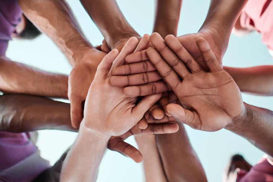 People, teamwork and hands together in collaboration, goals or community for motivation below. Closeup of group piling in team building, solidarity or trust in support for sports, rugby or match.