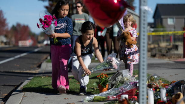Children place flowers at a makeshift memorial outside Silver Rail Elementary in Bend, Oregon, Friday, Oct. 16, 2026, a day after a deadly shooting. (Joe Kline/AP)