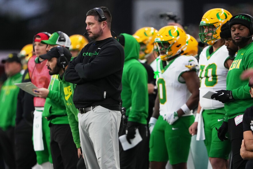 Oregon head coach Dan Lanning and players on the sidelines.