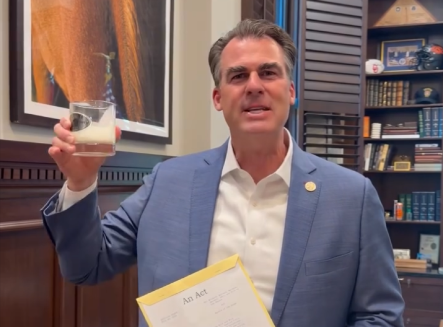 Gov. Kevin Stitt takes a drink from a glass of milk.