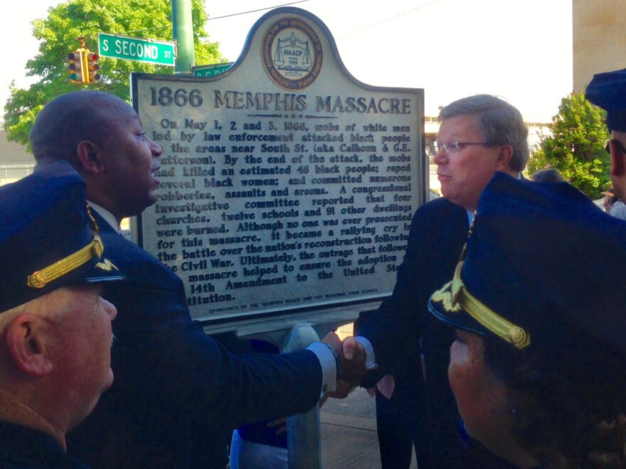 Memphis law enforcement looks on as the Rev. Keith Norman (left), president of the Memphis branch of the NAACP, shakes hands with Memphis Mayor Jim Strickland in front of the new historical marker.