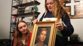 Ashley Crego and Sherry Lesher look at a painting of AJ