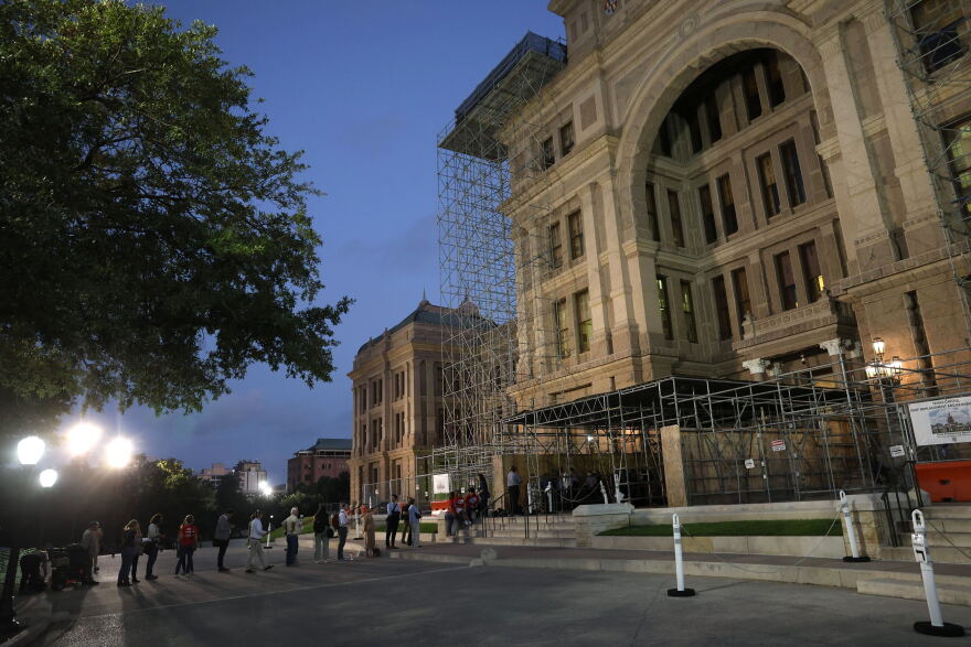 A line of people outside of the Texas Senate building.