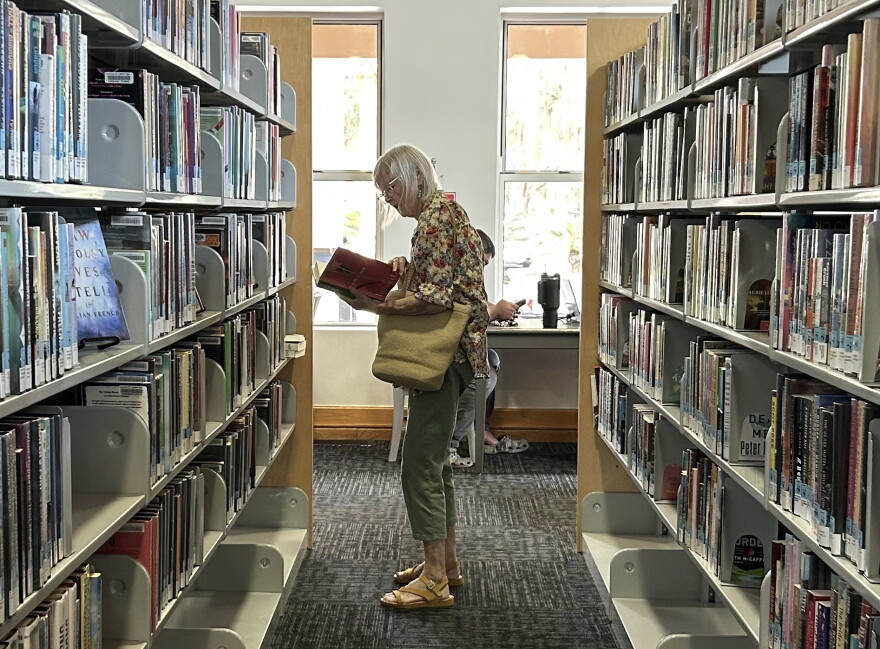 Lilly Vird pops into the Tower Road Branch once a month to scour the mystery and fiction aisles. "The library is an addiction," Vird said. (Molly Seghi/WUFT News)