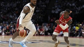 United States' forward LeBron James, left, and Germany's guard Dennis Schroeder challenge for the ball during an exhibition basketball game between the United States and Germany at the O2 Arena in London, Monday, July 22, 2024. (AP Photo/Alastair Grant)