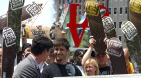 FILE - Skateboarders cheer as DC Shoes President Ken Block, center, wearing black shirt, smiles after pledging $1 million to support skateboarding in Philadelphia's LOVE Park on June 1, 2004. Block, the co-founder of DC Shoes and a pro rally driver who won multiple medals at the X-Games, died Monday, Jan. 2, 2023, in a snowmobiling accident near his home in Park City, Utah, authorities said. Block was 55.