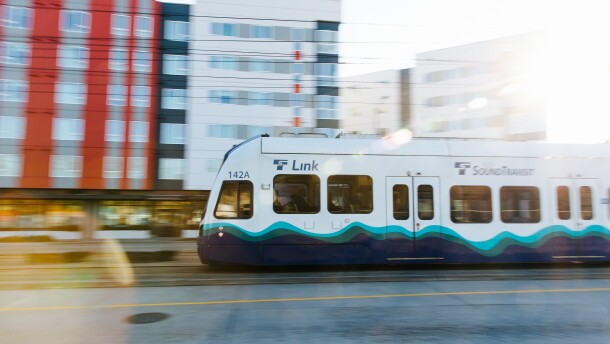 A train passes in front of apartment buildings. 