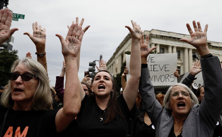 Outside the Kavanaugh hearing, people protest.