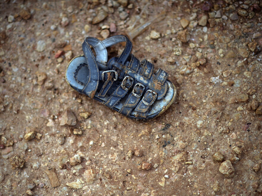 A child's shoe is left in the mud in the Zaatari refugee camp in Jordan. Even for the survivors, childhood vanishes.