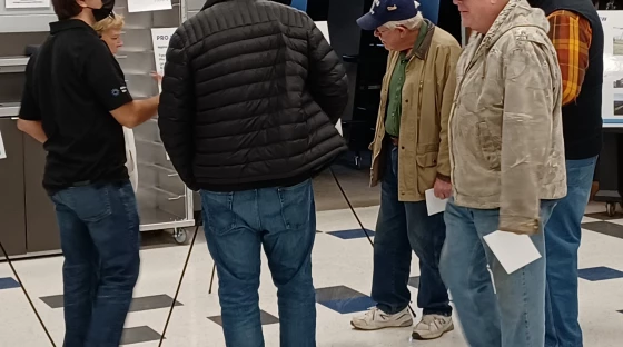 Minonk Solar project manager Eduardo Amaya (left, masked) talks with a group of Woodford County residents about his company's planned solar farm.