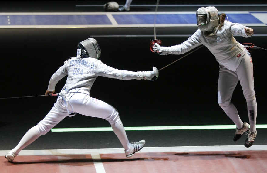 Ibtihaj Muhammad (left) competes with Tunisia's Hela Besbes during a women's team sabre qualifying match at the 2011 World Fencing Championships in Catania, Italy.