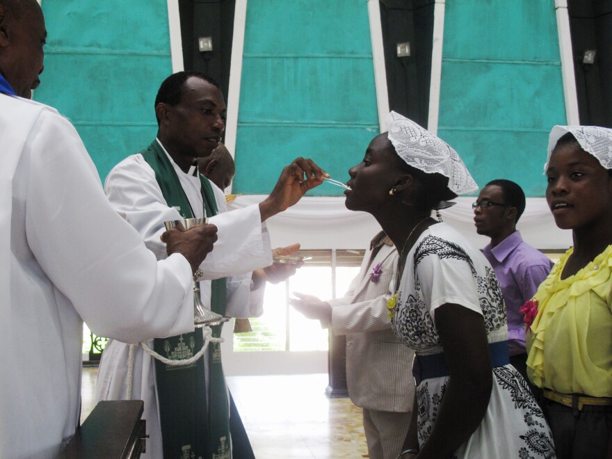 Priests use tweezers to deliver the Holy Communion wafer at Trinity Cathedral in Monrovia to prevent the spread of Ebola.