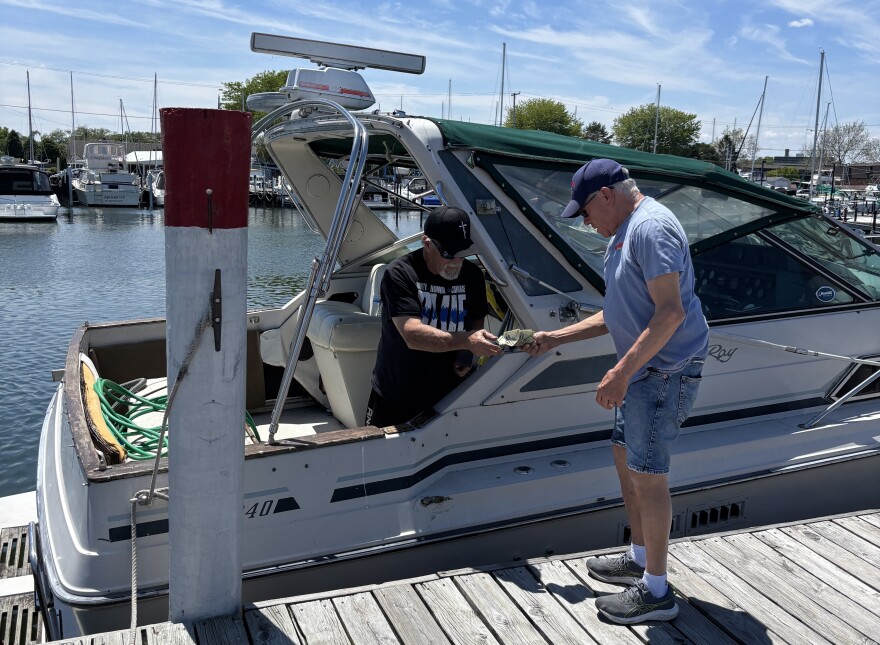 Bill Parilo (left) paying Mark Conley (right) in cash for fuel.