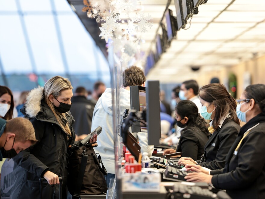 DULLES, VIRGINIA - DECEMBER 27: A woman checks in for her flight at a United Airlines kiosk at the Dulles International Airport on December 27, 2021 in Dulles, Virginia. According to media reports, at least 2,600 more flights were canceled Monday amid the surge in coronavirus cases, which have affected the staff within airlines. (Photo by Anna Moneymaker/Getty Images)