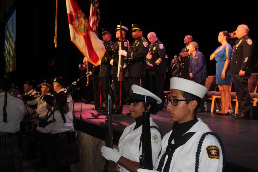 Uniformed service members salute the flag during 9-11 ceremony in the City of Clermont.  Photo: Jason Delgado