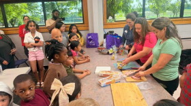 Adriana Figueroa, of K-State Extension, far right, with the can opener, teaches Dodge City Public Schools’ students and their families how to make healthy, family-friendly meals during an evening district-wide event.