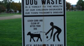File: Dog waste clean-up sign in a public park