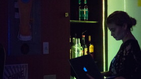 Tory Knight takes inventory at The Lost Whiskey in June. Part of the new proposal includes raising the amount of an establishment's revenue that must come from food sales to 60 percent.  